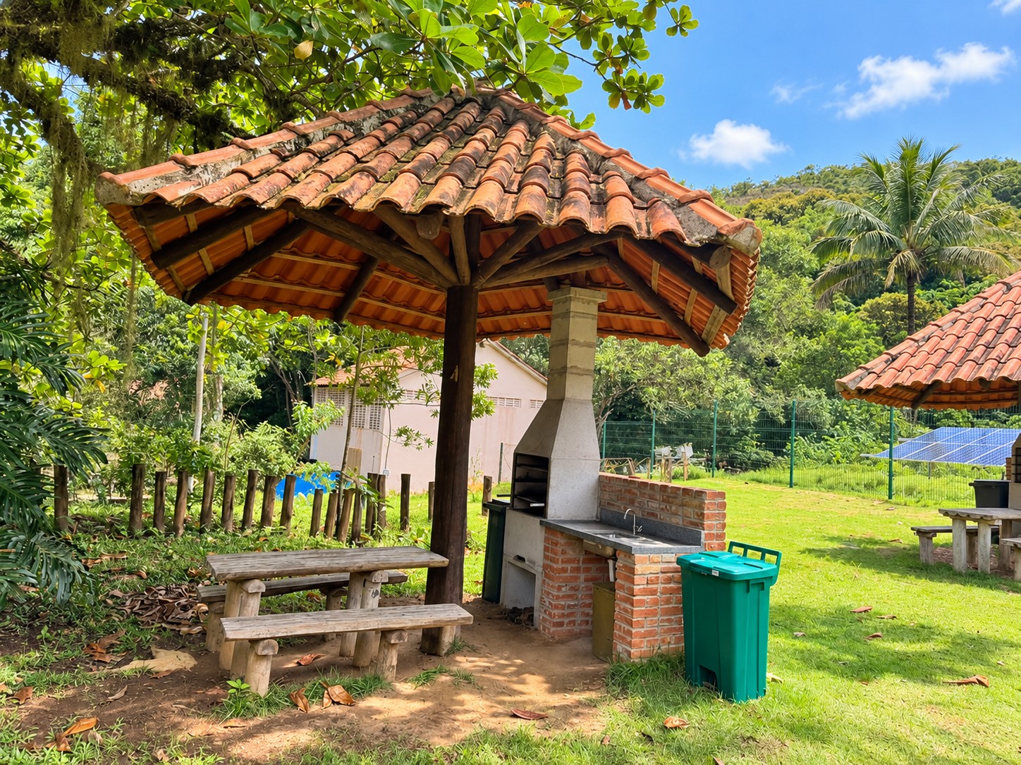 Quiosque com mesa de madeira, bancos e churrasqueira de alvenaria