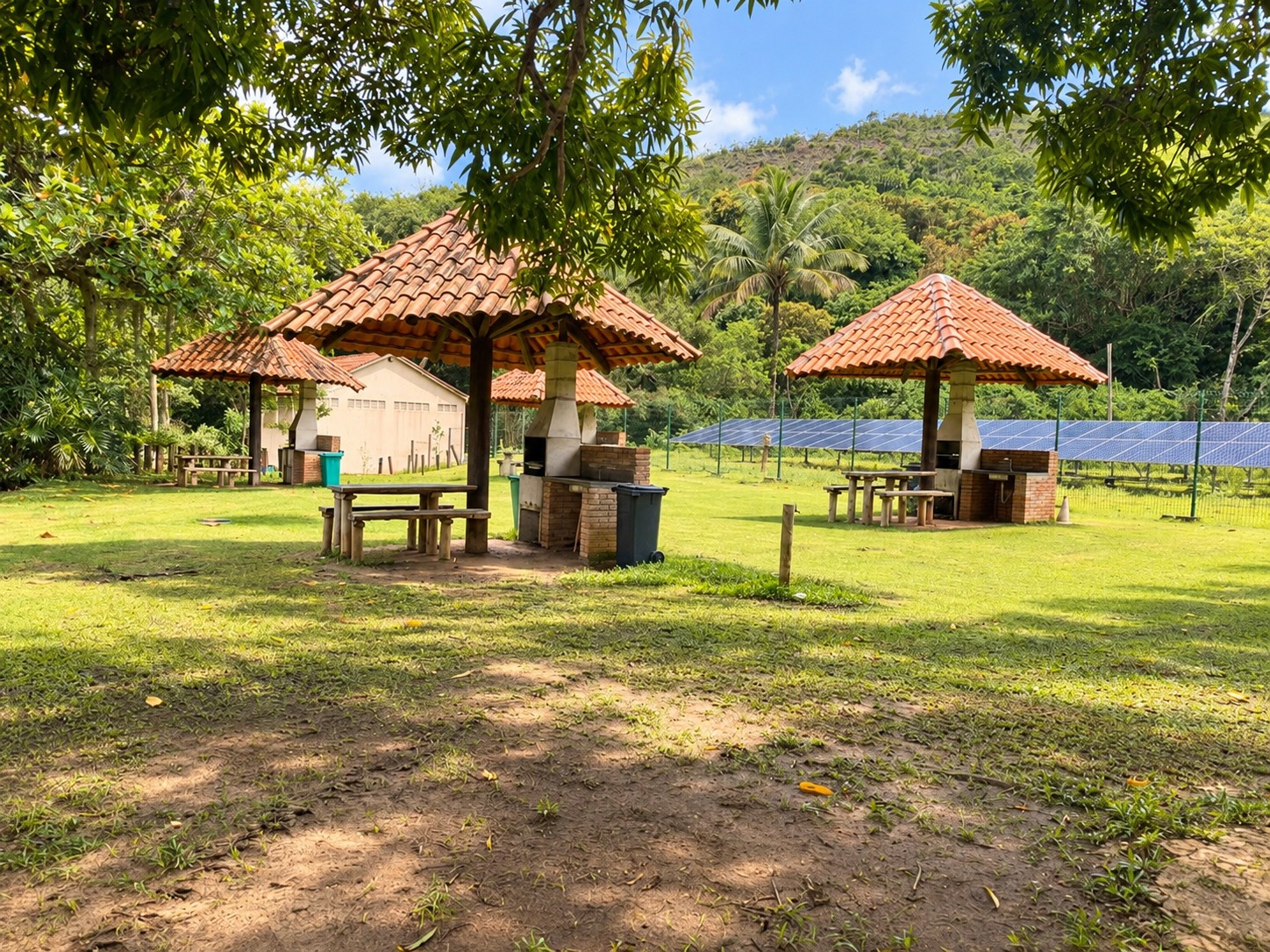 Quiosques com churrasqueira no gramado da Ilha Anchieta em um dia ensolarado